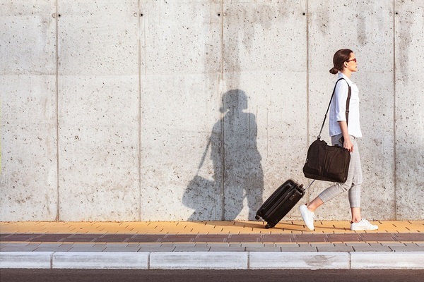 Person walking with a bag along a quiet city street
